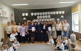 Pracownicy Przedszkola im. Zajączka Złocienaszka wraz z przybyłym gościem oraz z dziećmi.